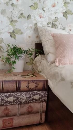 a bedroom with a bed and a plant on a table at Apartment on Brivzemnieka in Liepāja