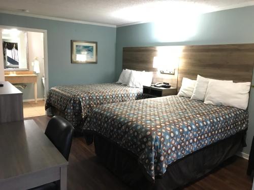 a hotel room with two beds and a desk at Winton Inn & Suites in Barnwell