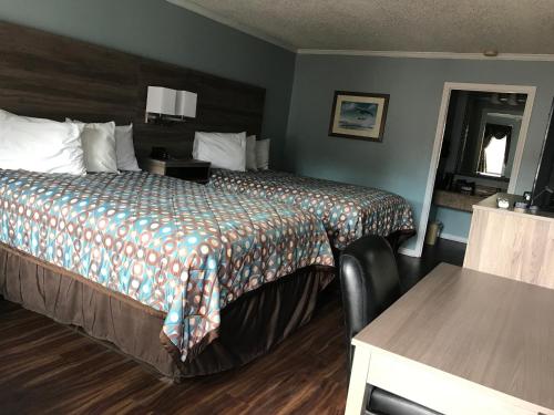 a hotel room with a bed and a table at Winton Inn & Suites in Barnwell