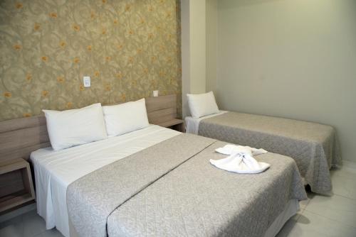 a hotel room with two beds with towels on them at AJ Hotel Chapecó - Fácil Acesso Pátio Shopping e Rótula da Bandeira in Chapecó