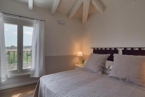 a bedroom with a large bed with a window at Appartamenti Palazzo Scolari in Polpenazze del Garda