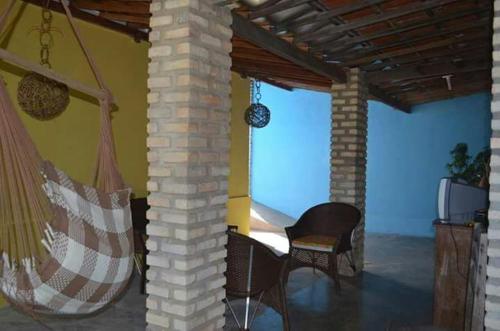 a room with a hammock and chairs and a tv at Pousada Cruzeiro dos Anjos in Tabatinga