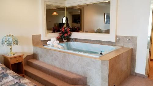 a bathtub in a room with stairs and a mirror at Western Budget Motel Cold Lake in Cold Lake