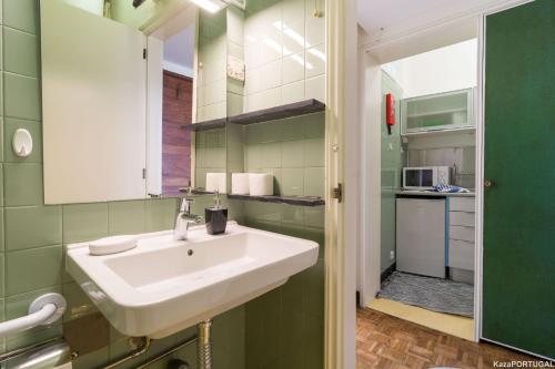 a bathroom with a sink and a small kitchen at Arcadas Delight in Estoril