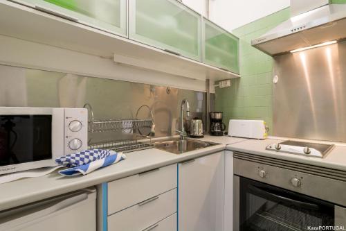 una cocina con fregadero y microondas en Arcadas Delight Studio, en Estoril