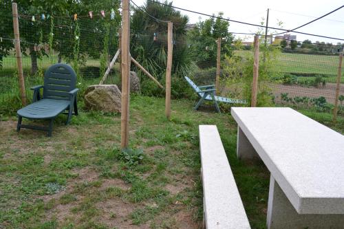 
a wooden bench in a grassy area next to a fence at Albergue Montoto in Melide
