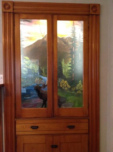 a wooden cabinet with three windows in a room at Strictly Moose Luxury Vacation Suites in Gorham