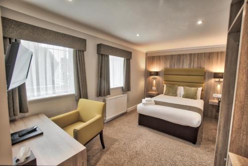 アビンドン・オン・テムズにあるスティーブントン ハウス ホテルのベッドとデスクが備わるホテルルームです。