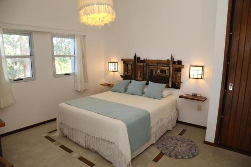 a bedroom with a large bed and a chandelier at Alma de La Pedrera - Villaggio & Spa in La Pedrera