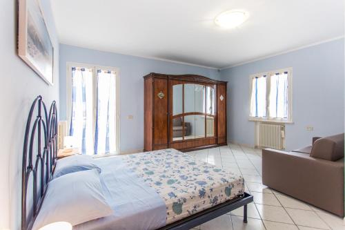a bedroom with a bed and a couch and windows at Residence Kimba in Rimini