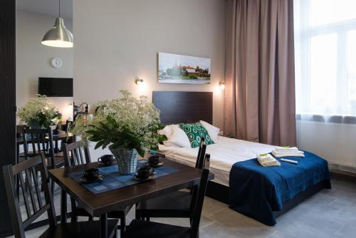 a room with a bed and a table and a dining room at Happy Tower in Kraków