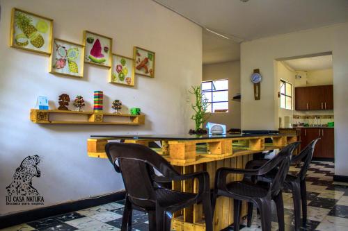 a restaurant with a bar with black chairs at Selvática Alojamiento Eco in Medellín