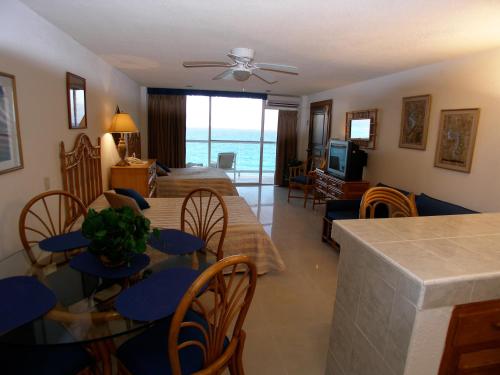 a dining room and living room with a view of the ocean at Salvia Cancun Aparts in Cancún