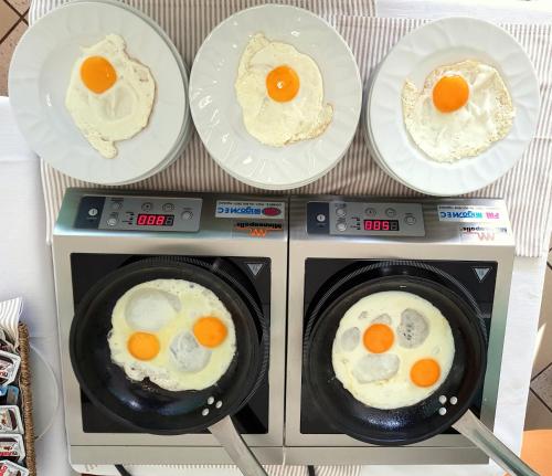 three plates of eggs on top of a microwave at Hotel Mediterraneo in Lignano Sabbiadoro