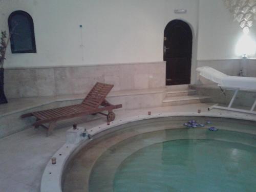 a pool with a bench and a chair in a room at Apartment Pavlovic in Soko Banja