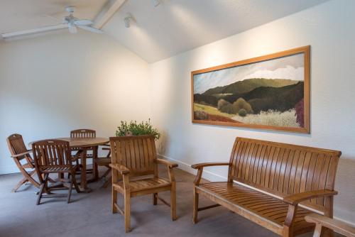 a dining room with a table and chairs and a painting at El Pueblo Inn in Sonoma