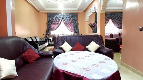 - un salon avec un canapé et une table dans l'établissement Villa Annakhil, à Marrakech