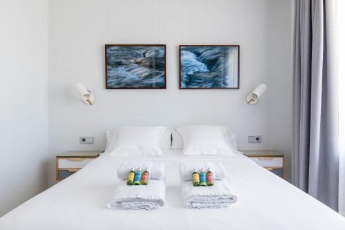 um quarto com uma cama branca com três fotografias na parede em Hotel Boutique Ca l'Agustina em Preixéns