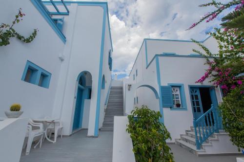 una scala che porta a un edificio bianco con porte blu di Preka Maria a Kamari