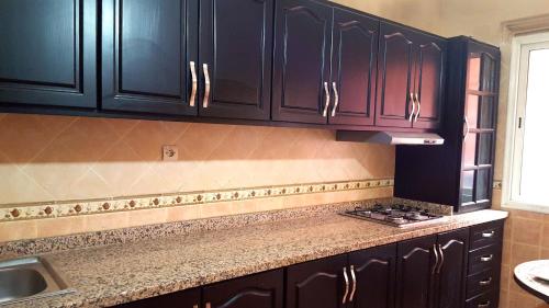 a kitchen with black cabinets and a counter top at Villa Annakhil in Marrakesh