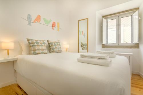 - une chambre blanche avec un grand lit blanc et des serviettes dans l'établissement Amazing Castle Views in Historic Center, à Lisbonne
