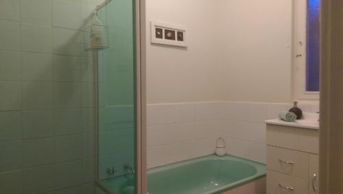 y baño con bañera verde y ducha. en My Port Lincoln Place, en Port Lincoln