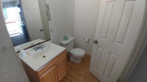 ein Badezimmer mit einem Waschbecken, einem WC und einem Spiegel in der Unterkunft Anchor Motel & RV Park in Surfside Beach