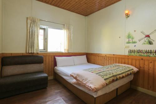 um pequeno quarto com uma cama e uma cadeira em Zhang Yi Ya Zhu Homestay em Baihe