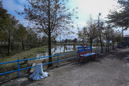 een blauw hek en een bank naast een rivier bij Zhang Yi Ya Zhu Homestay in Baihe