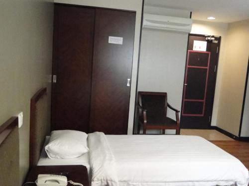 a small bedroom with a bed and a closet at Hotel Sadong88 in Kota Kinabalu