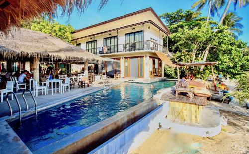 a resort with a swimming pool in front of a building at New Heaven Dive School and Resort in Koh Tao