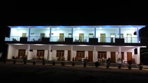 a large white building with a balcony at night at Sea Zone Hotel Nilaveli in Nilaveli