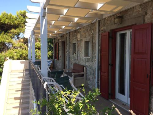 a porch with a red door and a patio at Heliades Maisonettes in Mithymna