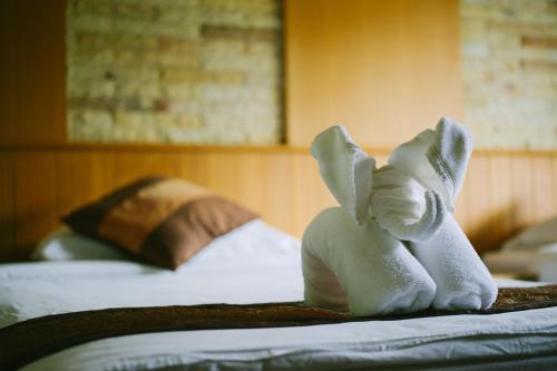 un elefante di peluche seduto sopra un letto di Phurua Resort a Phu Rua