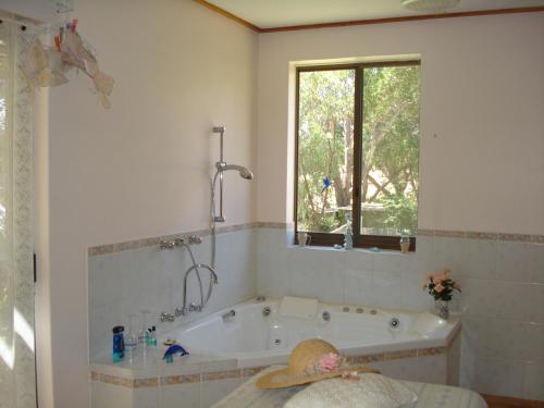 a bath tub in a bathroom with a window at pamelas retreat in Bridgetown