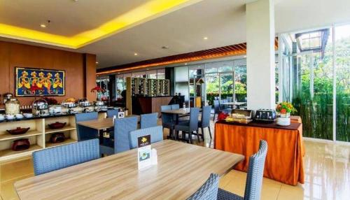 a dining room with tables and chairs and a restaurant at Moscato Hotel in Lembang