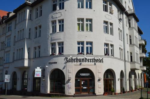 a tall white building with a sign on it at Jahrhunderthotel Leipzig in Leipzig