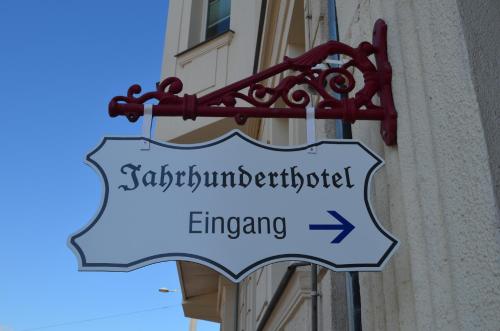 a street sign hanging off the side of a building at Jahrhunderthotel Leipzig in Leipzig