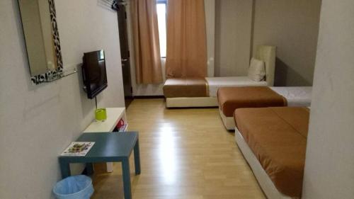 a small room with two beds and a tv at Selesa View Gambang in Simpang Pulau Manis