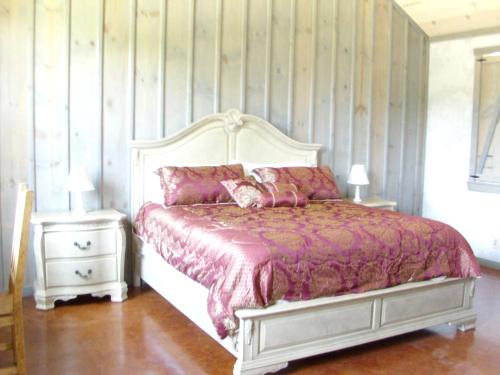a bedroom with a bed and two night stands at Breezy Hills Cottages - Morning Sun Cottage in Fredericksburg