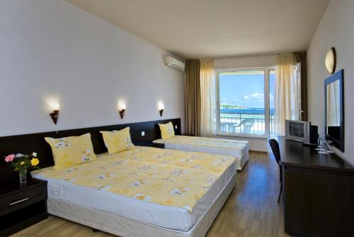 ソゾポルにあるСвети Никола Кавацитеのベッド2台と大きな窓が備わるホテルルームです。