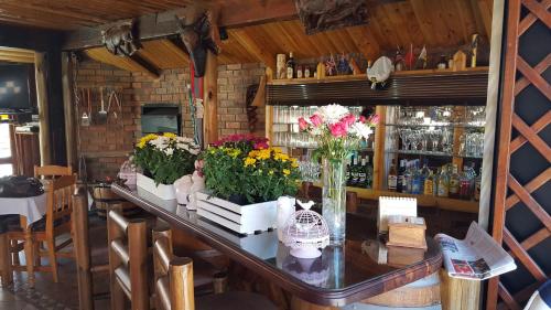 a bar with flowers on a table in a restaurant at Aark Guest Lodge in Vanderbijlpark