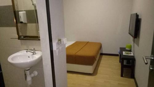 a small bathroom with a bed and a sink at Selesa View Gambang in Simpang Pulau Manis