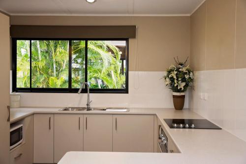 uma cozinha com um lavatório e uma janela em 7 McNamara - Wongaling Beach em Mission Beach