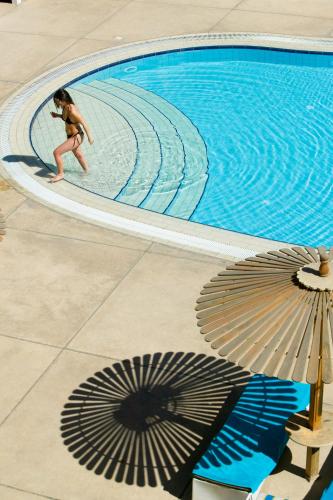 a woman in a bikini walking around a swimming pool at Aracan Eatabe Luxor Hotel in Luxor