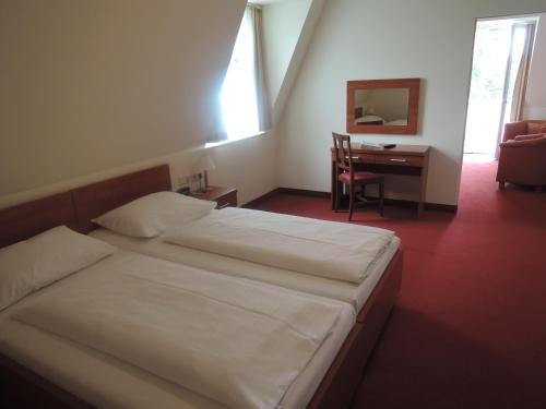 UnterkirchbachにあるHotel Restaurant Marienhofのベッドと机と椅子のある寝室