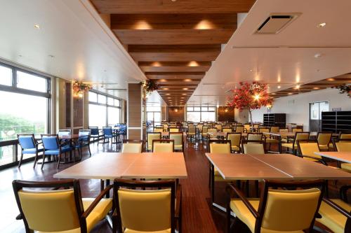 a dining room with tables and chairs and windows at Vessel Hotel Campana Okinawa in Chatan