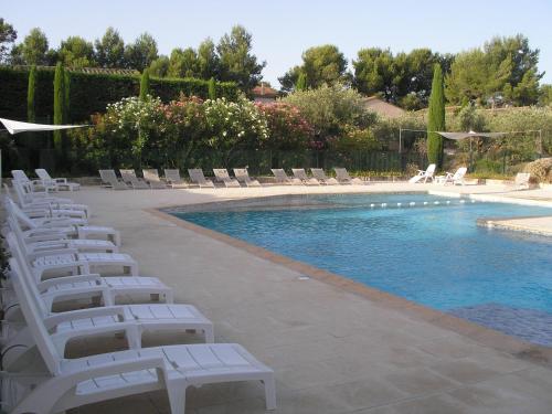 a pool with white lounge chairs and a swimming pool at Le Mazet De Lélé in Saint-Rémy-de-Provence