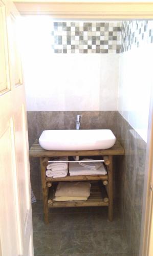 a bathroom with a sink on a wooden table at WAYNES' VILLA in Flic-en-Flac