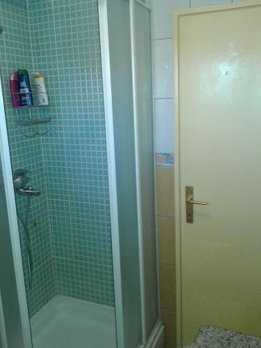 a bathroom with a shower with blue tile at Apartments Anita in Srima